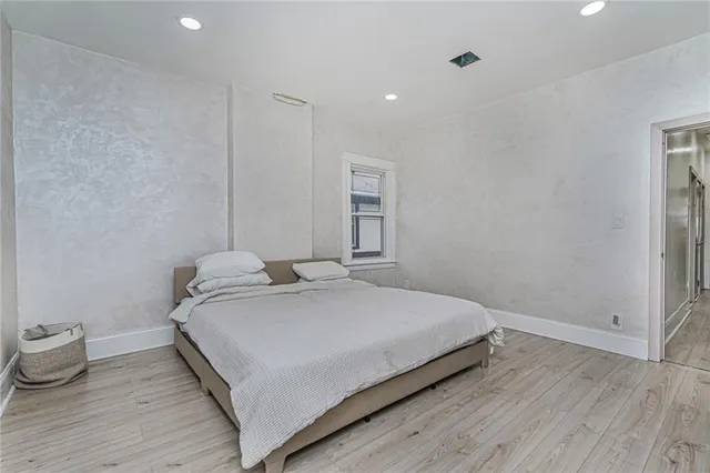 a bedroom with a bed and wooden floor