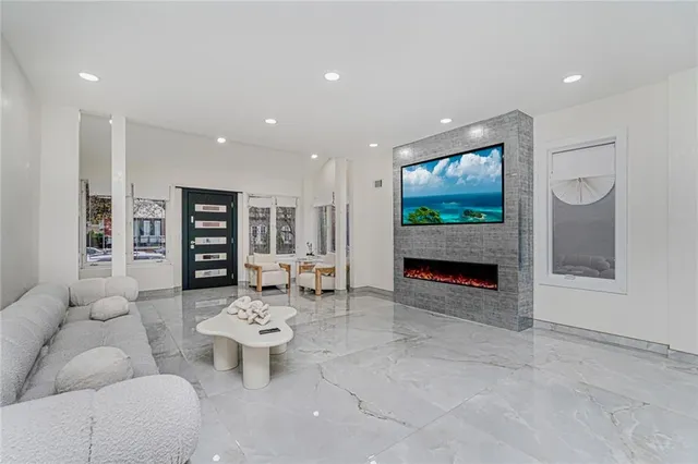 a living room with furniture a fireplace and a flat screen tv