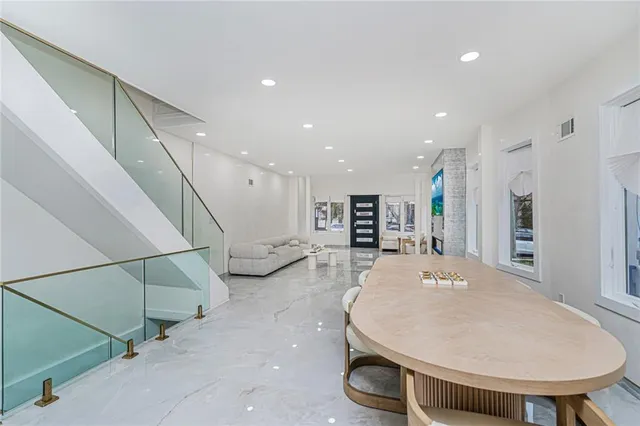 a living room with stainless steel appliances furniture and a wooden floor