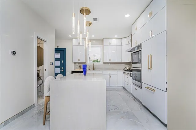 a kitchen with white cabinets and stainless steel appliances