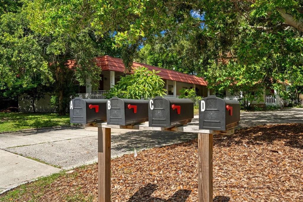 1156 Orange Avenue, Unit A B C D Dunedin, FL 34698 - Photo 2 of 7 a street sign on a sidewalk next to a road