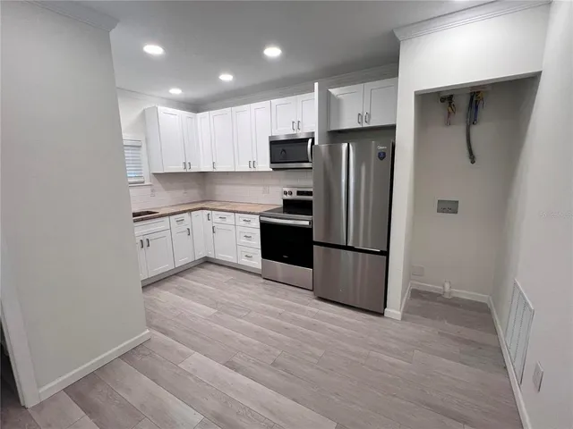 a kitchen with stainless steel appliances granite countertop a refrigerator and a stove top oven
