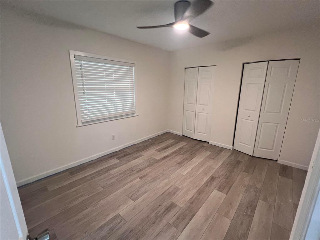 1156 Orange Avenue, Unit A B C D Dunedin, FL 34698 - Photo 6 of 7 an empty room with wooden floor cabinet and windows