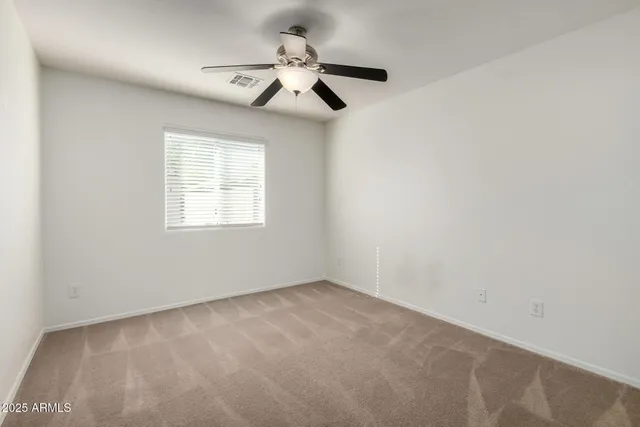 an empty room with a window and a fan