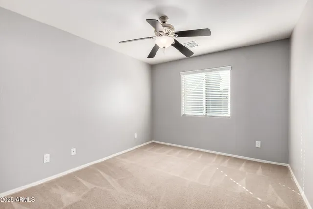 an empty room with a window and a fan