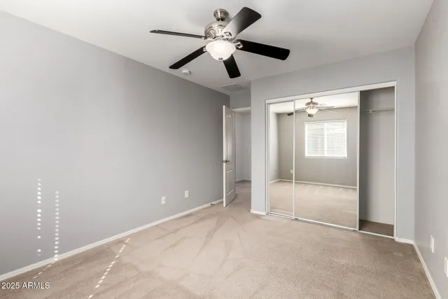 a view of an empty room and a ceiling fan