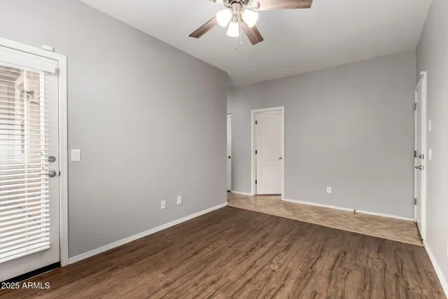 an empty room with wooden floor and windows
