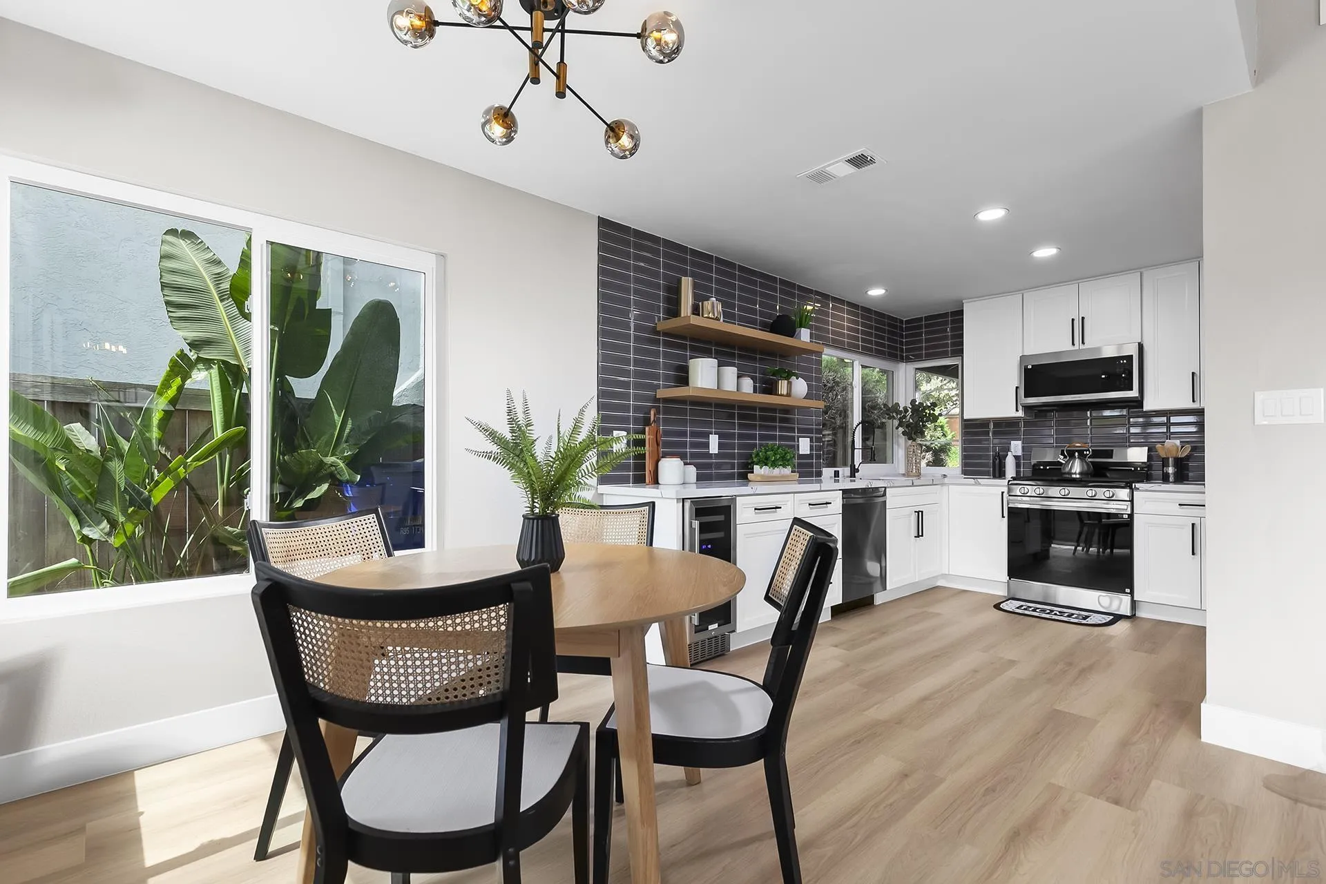 3226 Old Heather Road San Diego, CA 92111 - Photo 16 of 45 a kitchen with a table chairs refrigerator and microwave