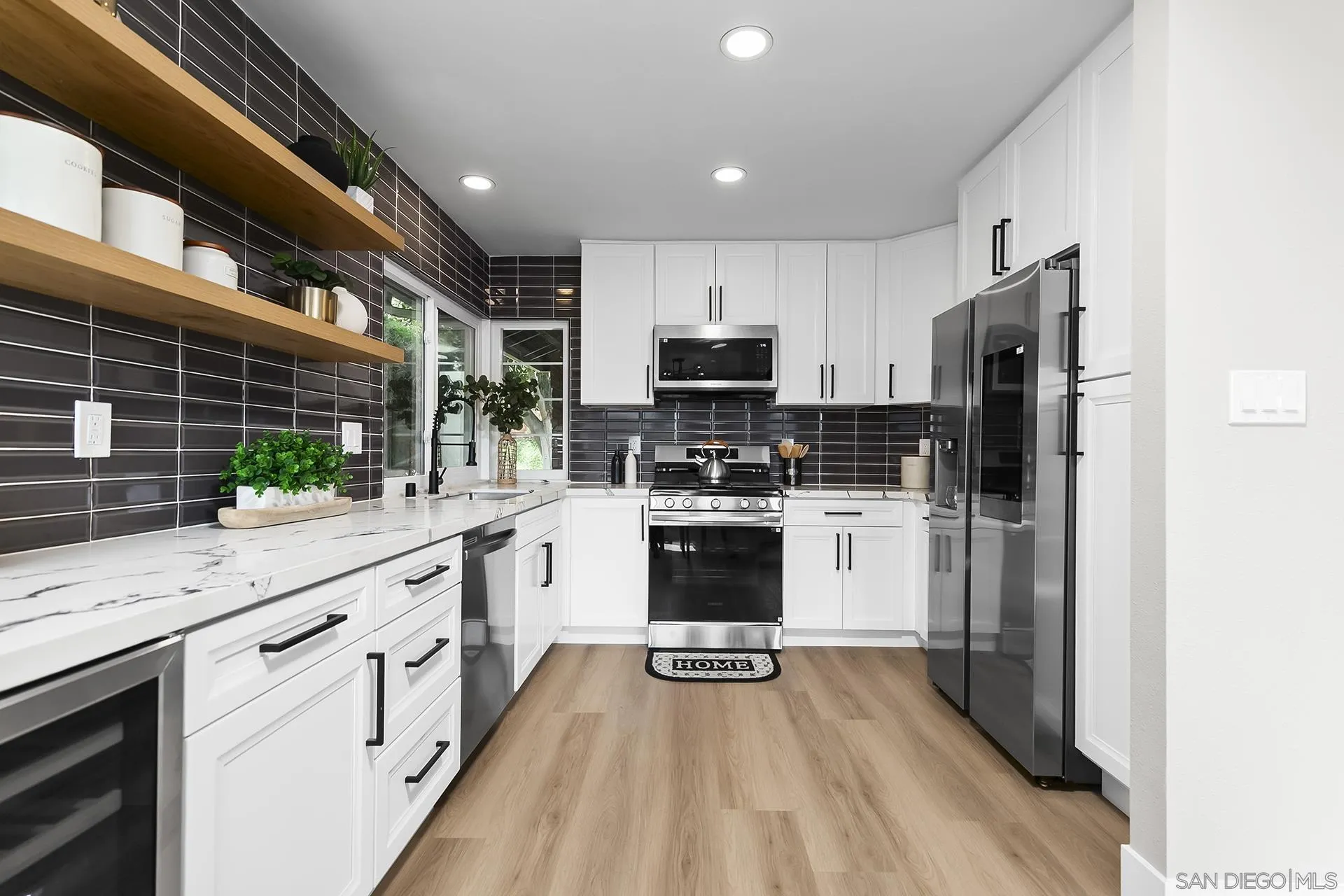3226 Old Heather Road San Diego, CA 92111 - Photo 19 of 45 a kitchen with white cabinets and stainless steel appliances
