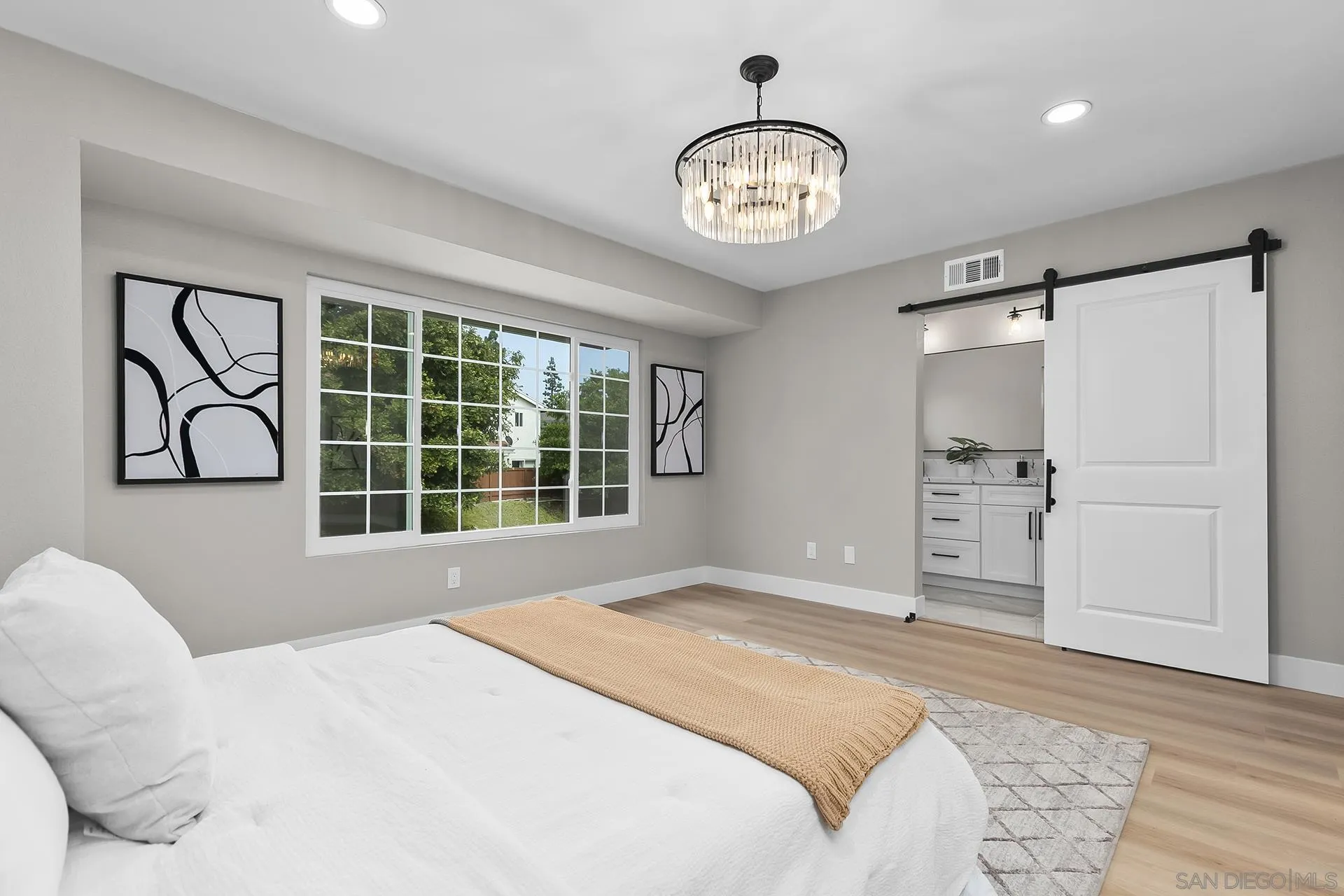 3226 Old Heather Road San Diego, CA 92111 - Photo 29 of 45 a bedroom with a large bed and a chandelier