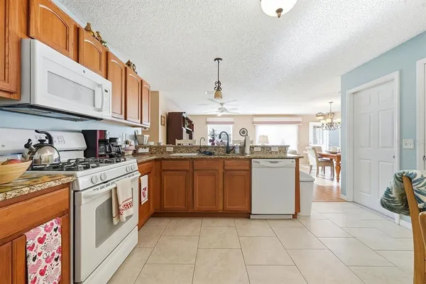 a kitchen with stainless steel appliances granite countertop a stove a sink and a refrigerator