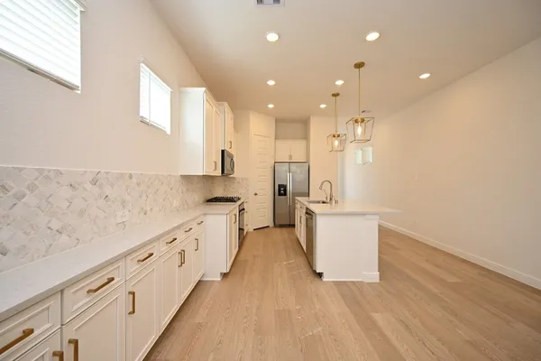 a kitchen with a sink a refrigerator and a stove top oven