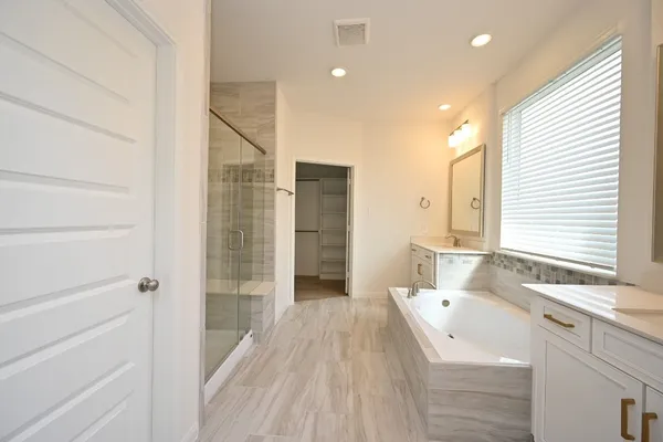 a bathroom with a double vanity sink a mirror and a shower