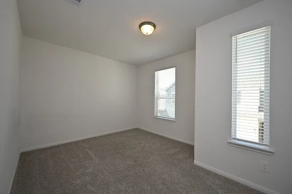 a view of an empty room with a window and closet area