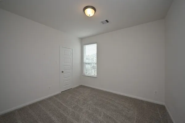 an empty room with windows and closet area