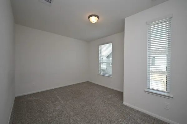 an empty room with windows and closet