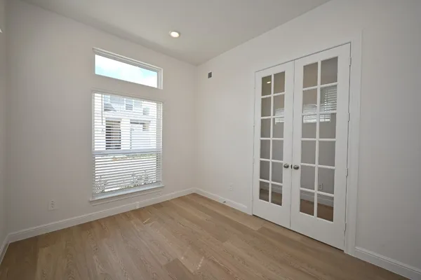 an empty room with wooden floor and windows