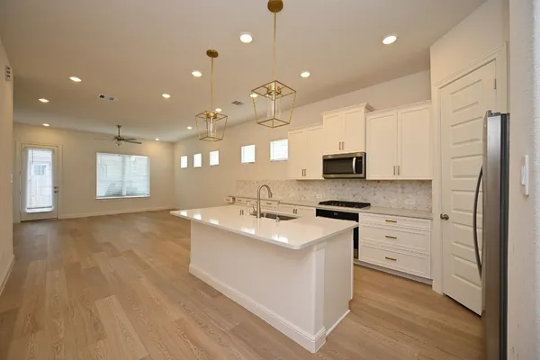 a kitchen with stainless steel appliances granite countertop a sink stove and refrigerator