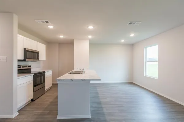 a kitchen with kitchen island granite countertop stainless steel appliances stove sink and microwave