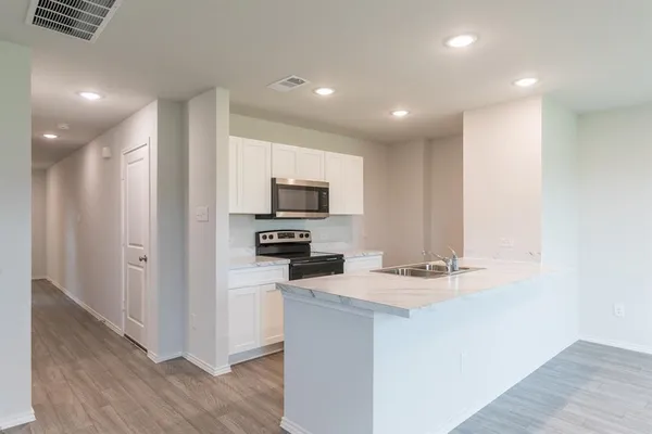a kitchen with appliances a sink and cabinets