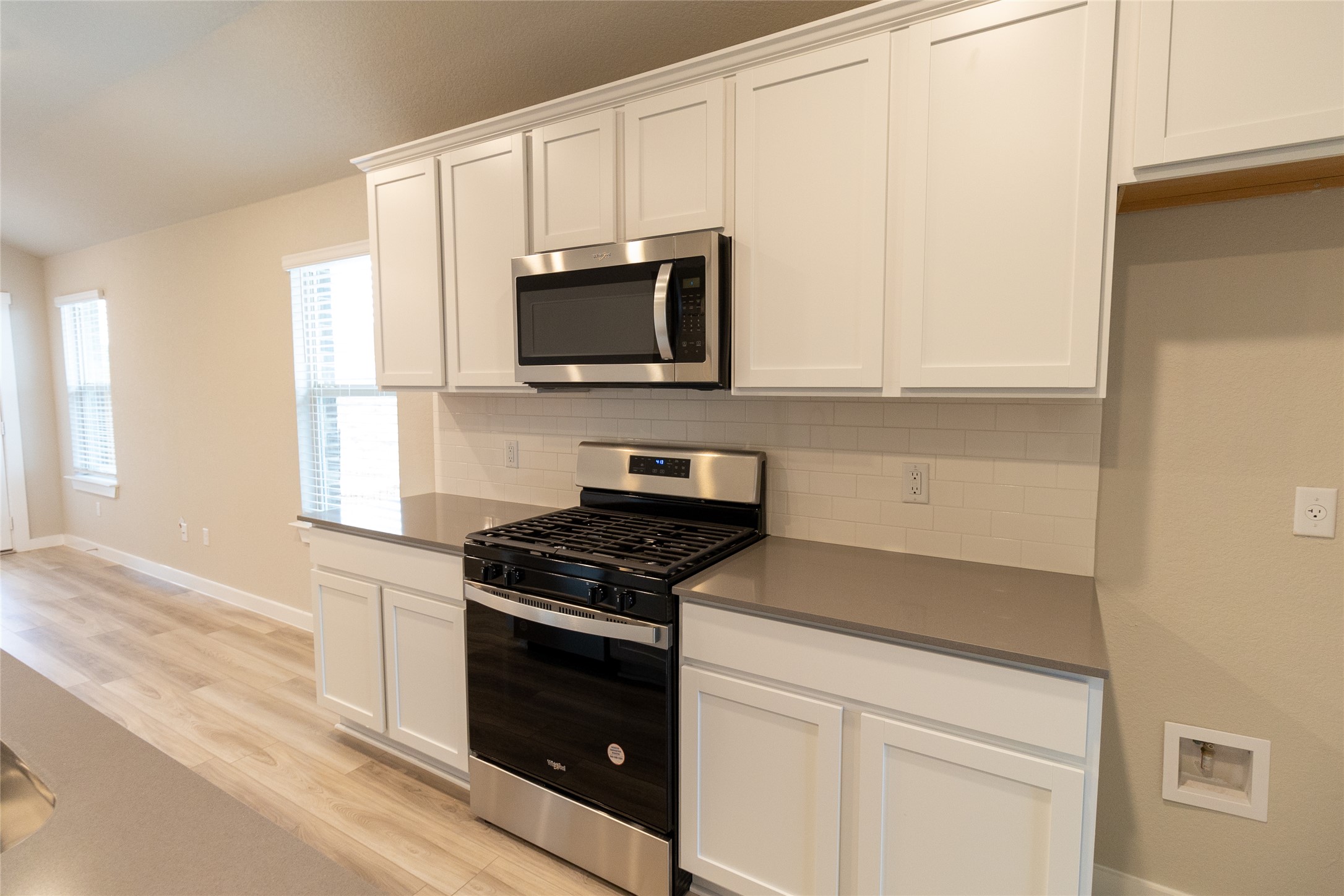 325 Coda Crossing Georgetown, TX 78633 - Photo 8 of 24 a kitchen with white cabinets and black appliances