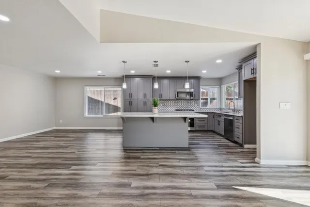 a kitchen with granite countertop a sink stove and refrigerator