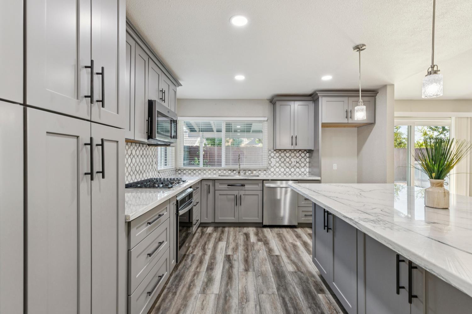 2612 Star Oak Court Modesto, CA 95355 - Photo 20 of 26 a kitchen with granite countertop a sink stove and refrigerator