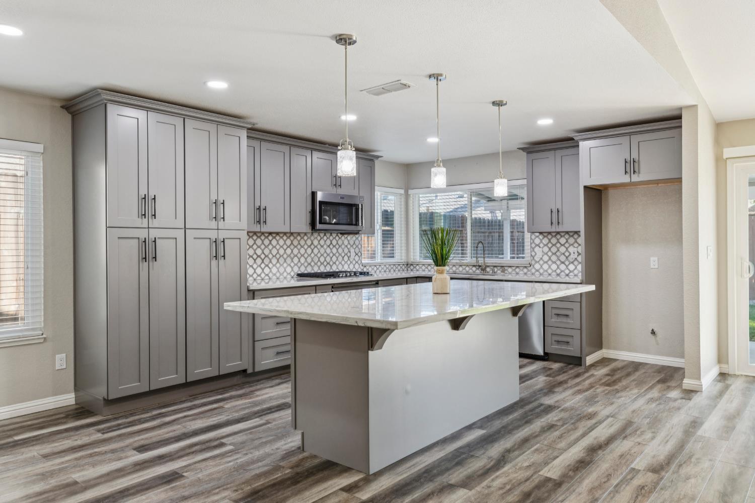 2612 Star Oak Court Modesto, CA 95355 - Photo 21 of 26 a kitchen with kitchen island granite countertop a sink appliances cabinets and counter space
