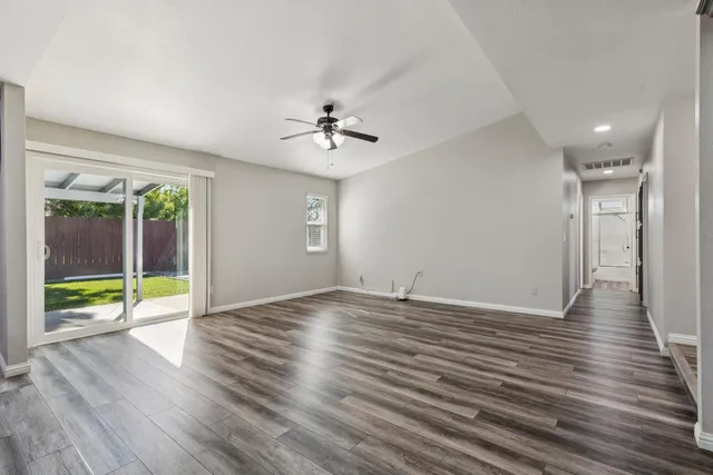 a view of a kitchen with wooden floor and a ceiling fan