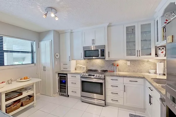 a kitchen with cabinets appliances and a window