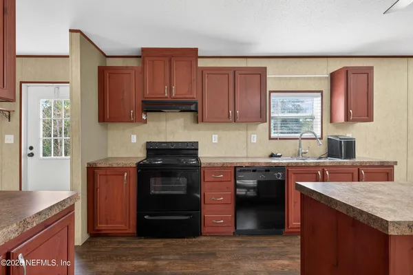 a kitchen with stainless steel appliances granite countertop a stove sink and cabinets