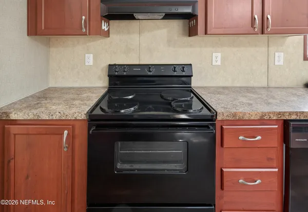 a stove top oven sitting inside of a kitchen