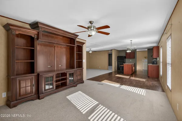 a view of an empty room with furniture and a window