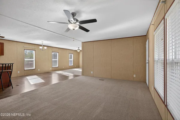 a view of a livingroom with a ceiling fan and window
