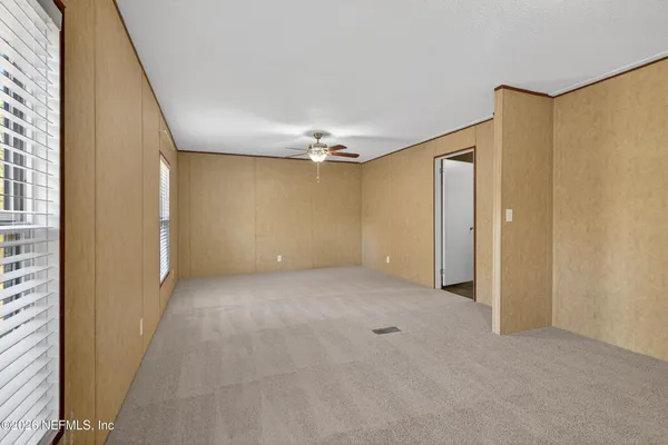 a view of a big room with chandelier fan and windows