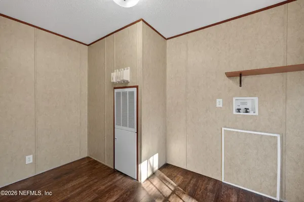 a view of empty room with wooden floor