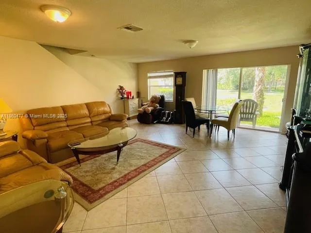 a living room with furniture and a floor to ceiling window