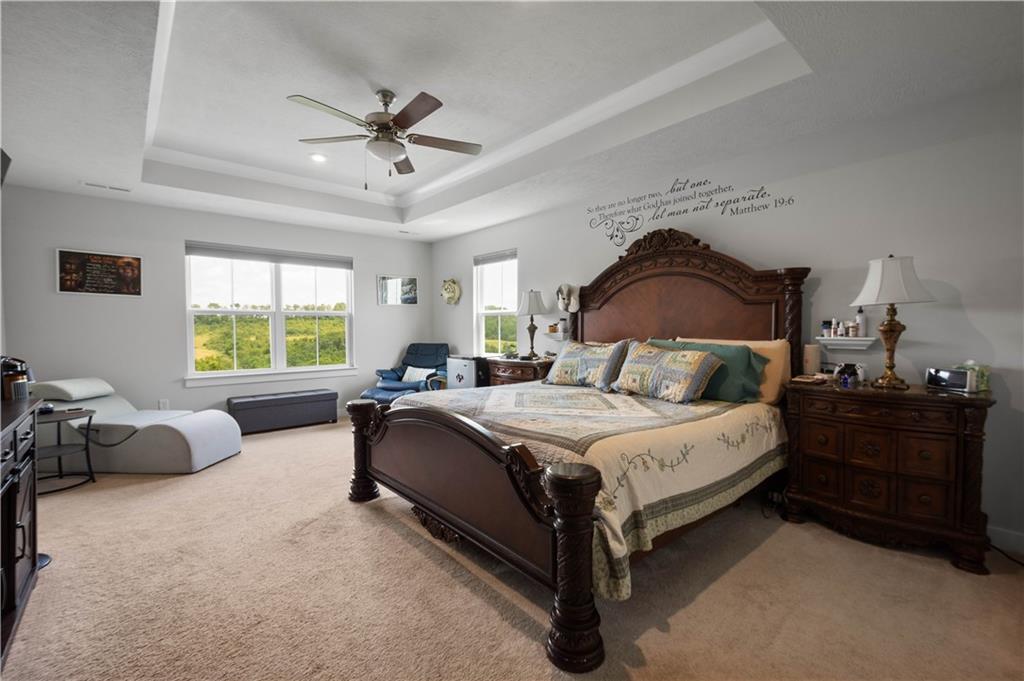 254 Regency Drive Eighty Four, PA 15330 - Photo 18 of 44 Generously sized primary bedroom with a tray ceiling, crown molding and a ceiling fan. Large windows overlook the scenic view!
