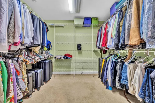a view of walk in closet with clothes and shoes
