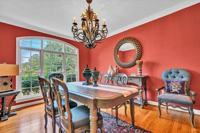 a view of a dining room with furniture a chandelier and wooden floor