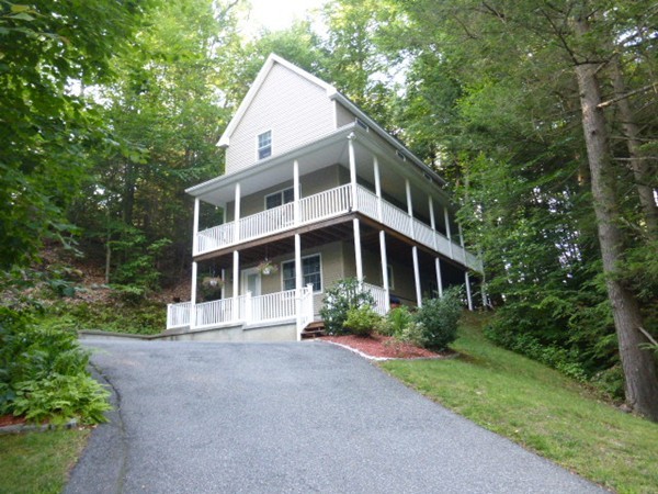 a front view of a house with a yard and trees