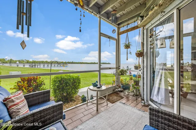 a patio with glass top table and chairs