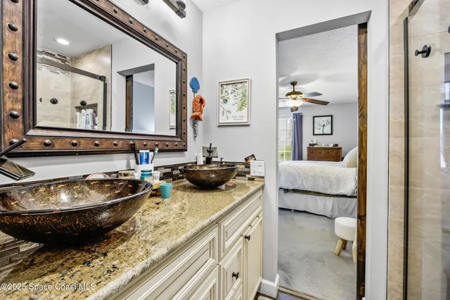 a bathroom with a granite countertop sink and a mirror