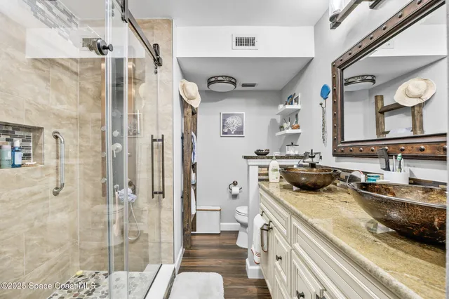 a bathroom with a sink a toilet and shower