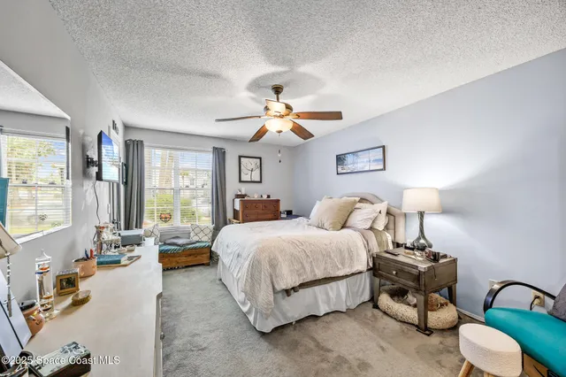 a spacious bedroom with a bed couch and window