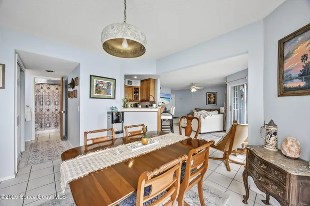 a room with chandelier fan and windows