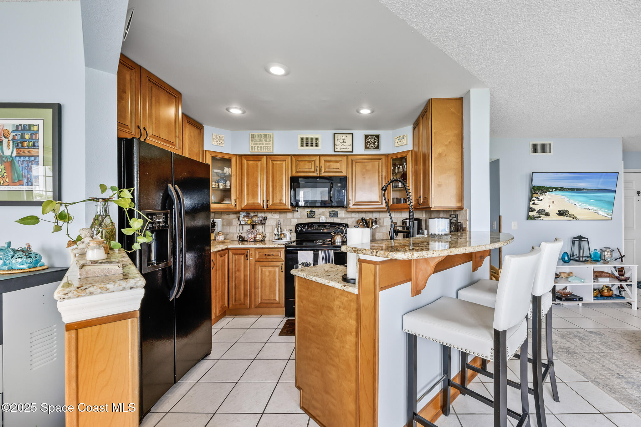 7420 U.S. Rte 1, Unit 106 Cocoa, FL 32927 - Photo 35 of 41 a kitchen view with stainless steel appliances kitchen island granite countertop a refrigerator and a stove top oven