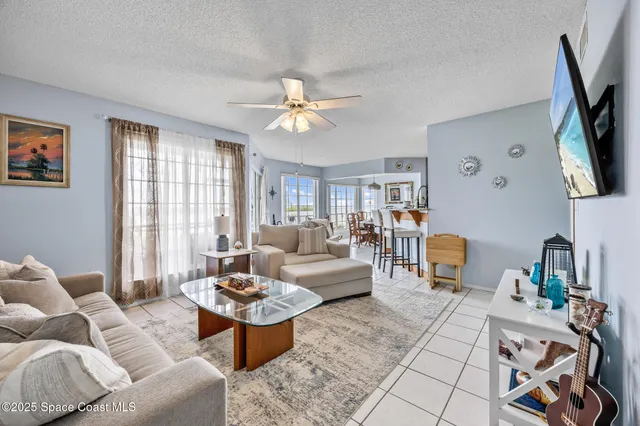 a dining room with furniture a flat screen tv and a floor to ceiling window
