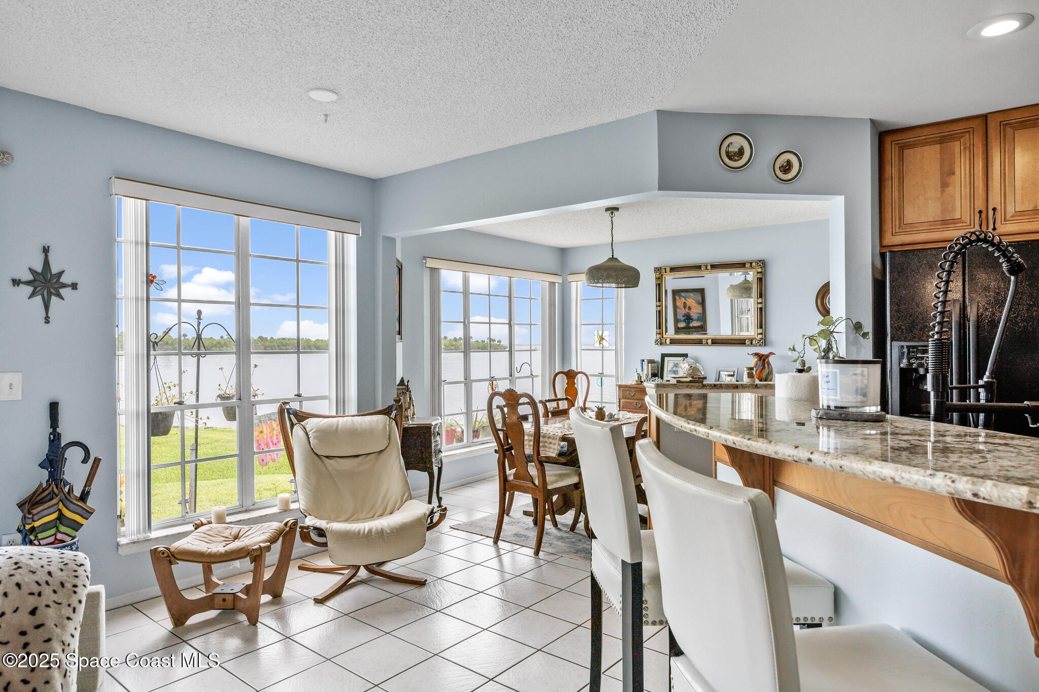 7420 U.S. Rte 1, Unit 106 Cocoa, FL 32927 - Photo 40 of 41 a dining room with furniture a flat screen tv and a floor to ceiling window