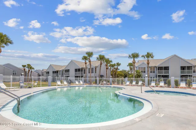 a view of a swimming pool in front of residential houses